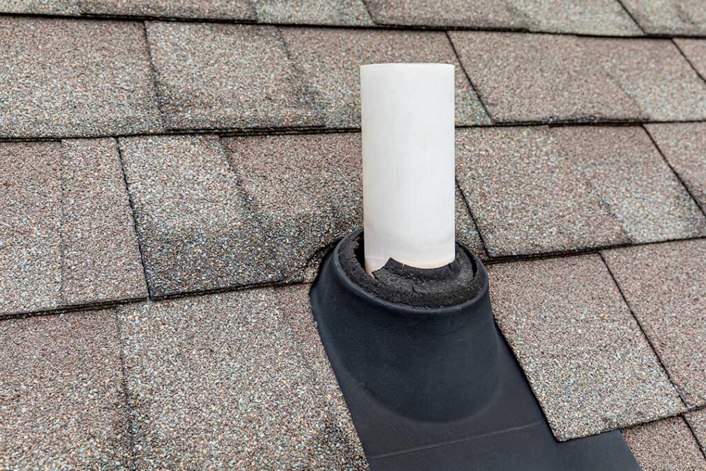 A homeowner compares a new asphalt shingle sample with weathered shingles on a residential roof.